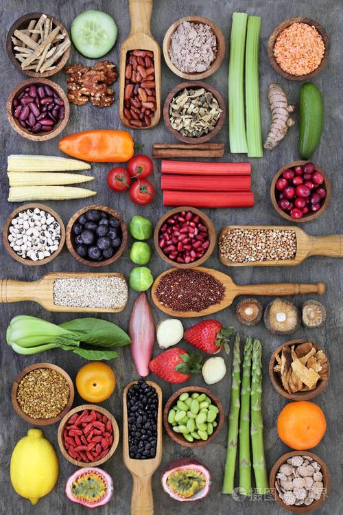 健康的营养食品概念与豆类水果谷物种子草药花粉粒和香料大理石在木碗